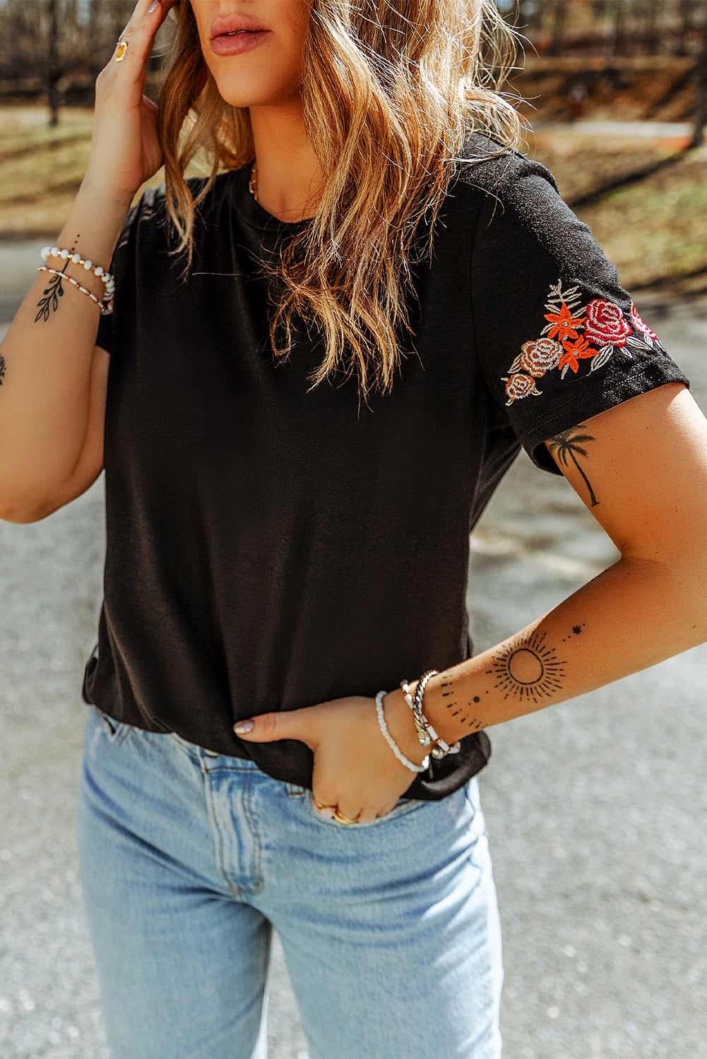 Black T-shirt with short sleeves and round neck embroidered with flowers