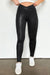 Elegantes leggings de cuero negro con cintura cruzada