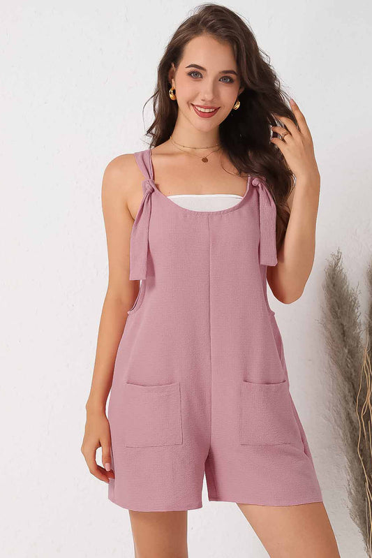 Pink textured romper with adjustable straps and pockets