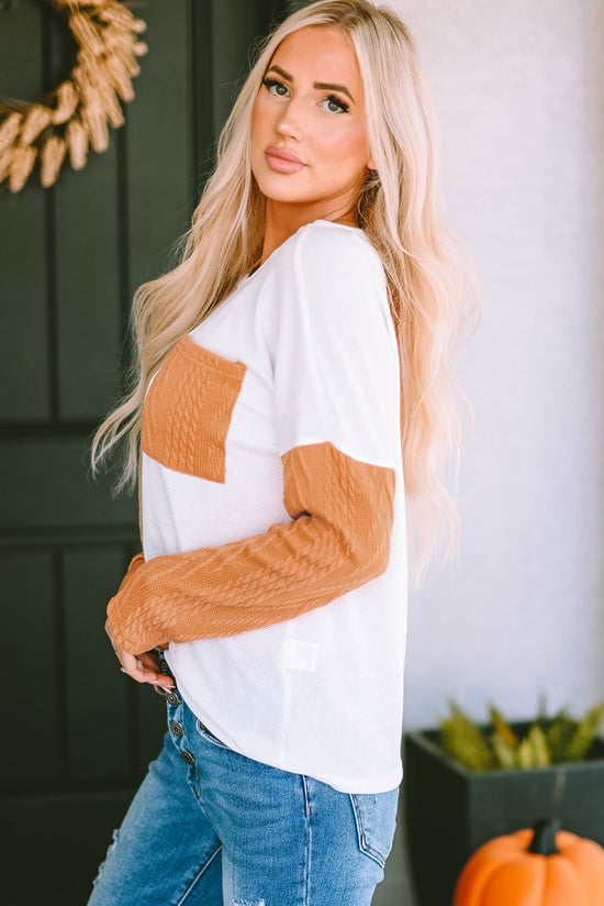 Orange textured knit top with long sleeves and color block chest pocket